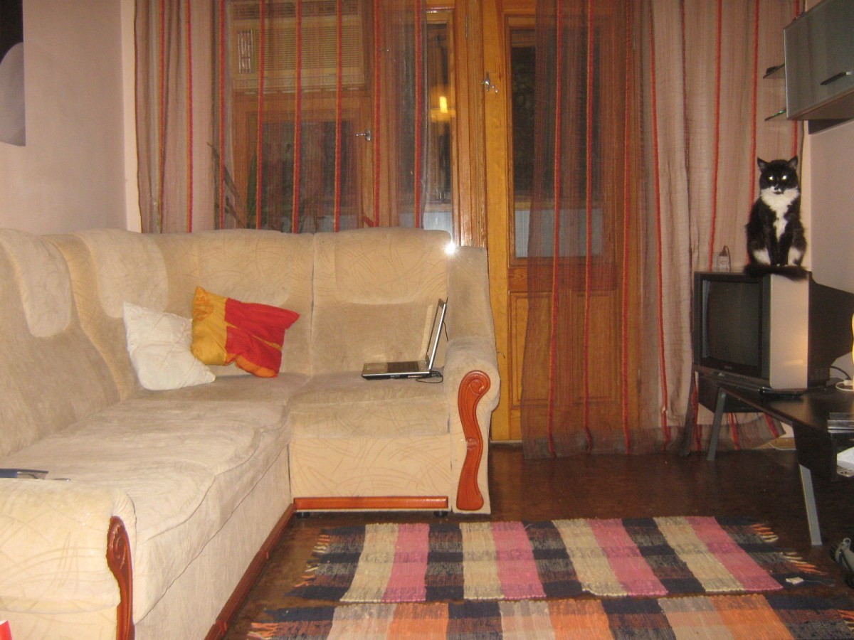 Угловой диван в комнате с балконом