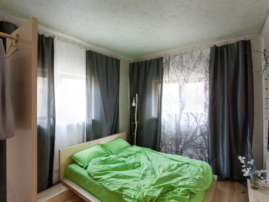 Интерьер спальни с двумя окнами на разных стенах в доме